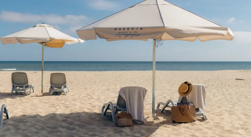 Leżaki i parasole na piaszczystej plaży nad morzem.